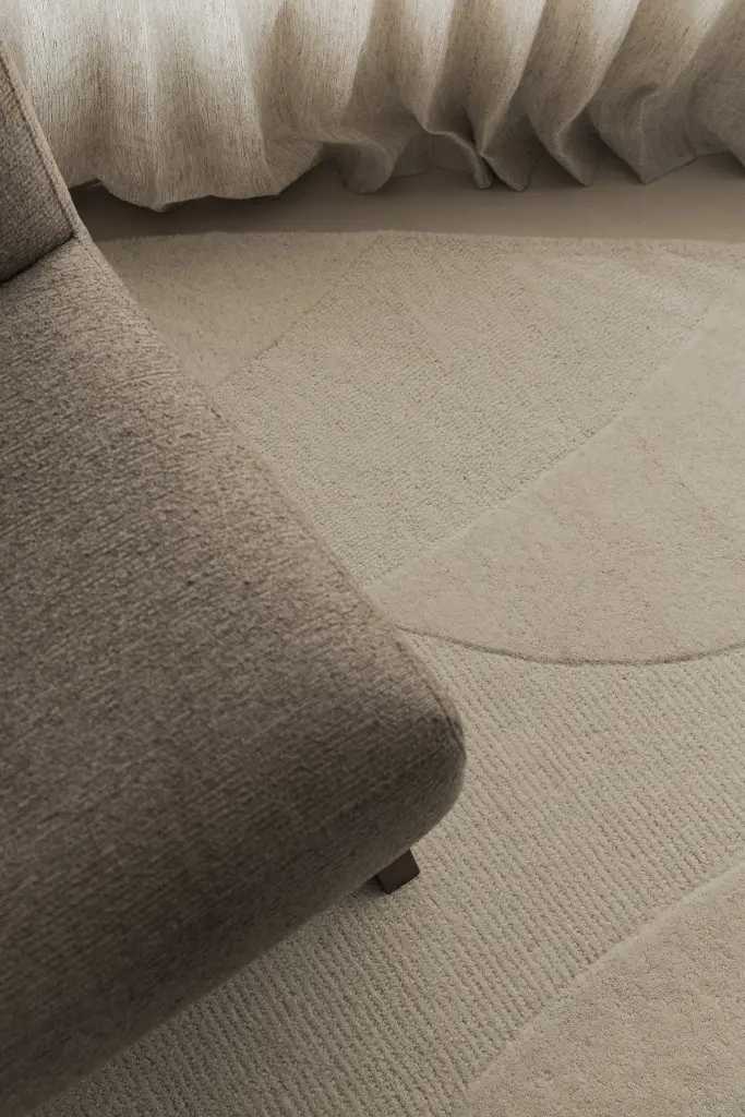 Detail van een bouclé fauteuil op wollen tapijt, Nieuwbouwwoning in Roeselare, interieur Laura Calleeuw