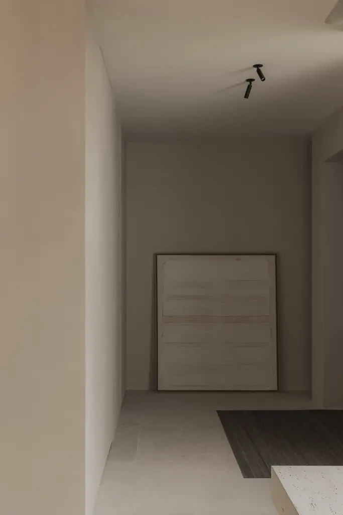 Inkomhal met microcement wanden en groot wit schilderij op de grond, Nieuwbouwwoning in Roeselare, interieur Laura Calleeuw