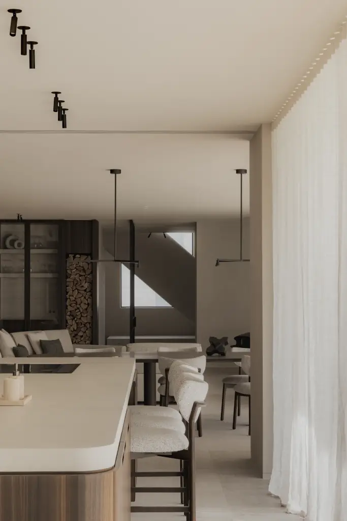 Keuken met eiland en doorkijk naar de leefruimte achter lange gordijnen, Nieuwbouwwoning in Roeselare, interieur Laura Calleeuw
