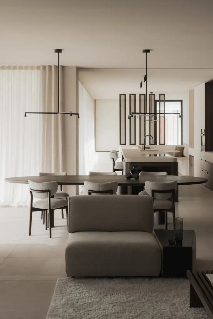 Open leefruimte met zithoek, televisie, ovale eettafel en keuken, Nieuwbouwwoning in Roeselare, interieur Laura Calleeuw