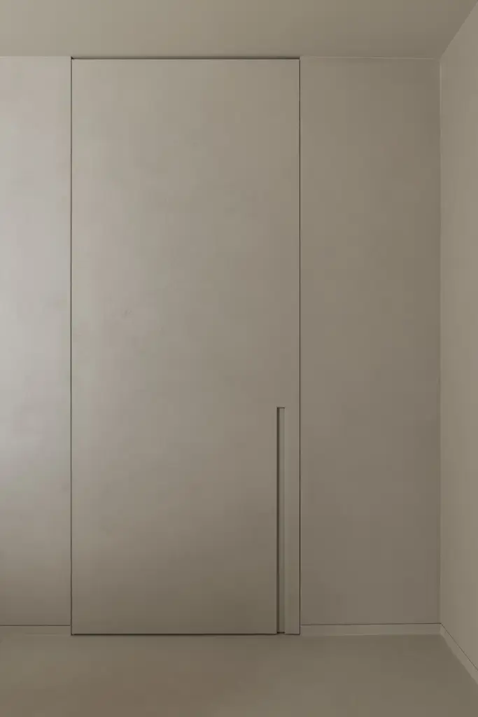 Onzichtbare inbouwdeur in een microcement wand, Nieuwbouwwoning in Roeselare, interieur Laura Calleeuw