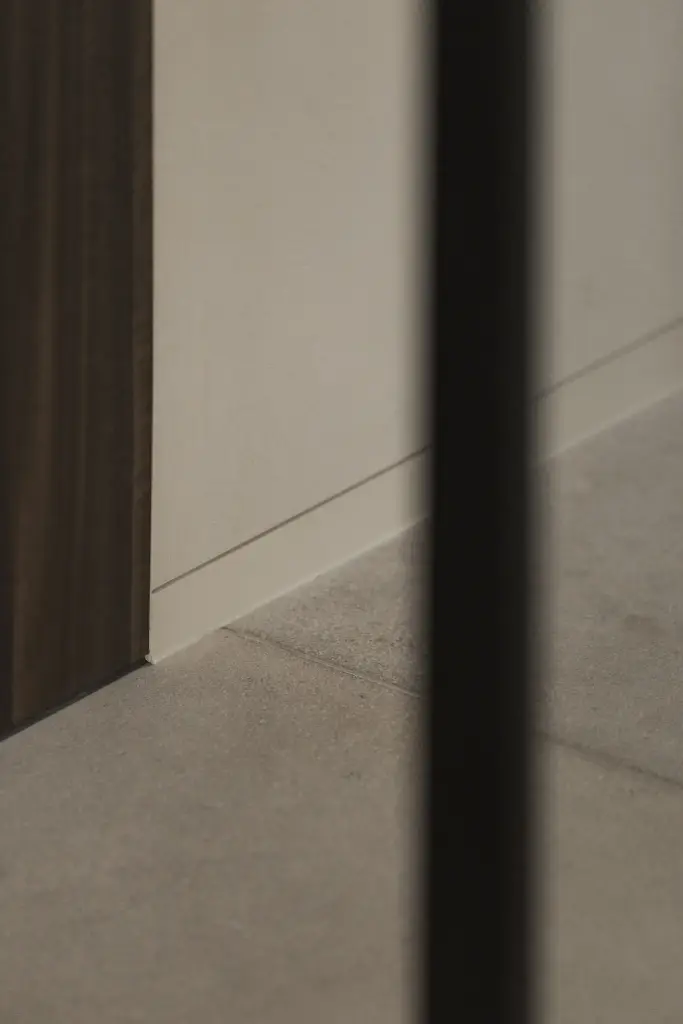 Detail van plint en vloer met zwart staalprofiel, Nieuwbouwwoning in Roeselare, interieur Laura Calleeuw