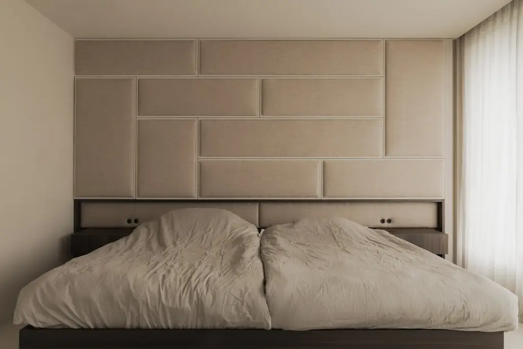 Slaapkamer met bed en hoofdbord van gestoffeerde panelen in linnen, Nieuwbouwwoning in Roeselare, interieur Laura Calleeuw