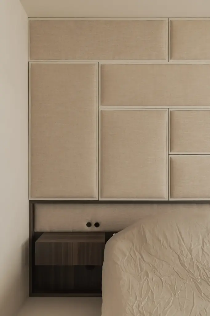 Slaapkamer met bed en hoofdbord van gestoffeerde panelen in linnen, Nieuwbouwwoning in Roeselare, interieur Laura Calleeuw
