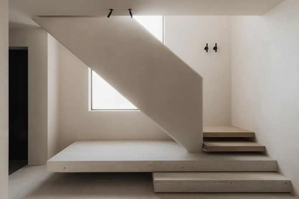 Trap met travertijn podium en zwevende eiken treden onder een raam, Nieuwbouwwoning in Roeselare, interieur Laura Calleeuw