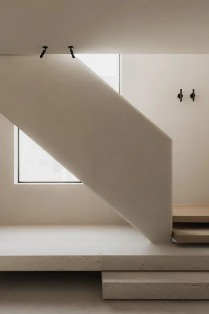 Trap met travertijn podium en zwevende eiken treden onder een raam, Nieuwbouwwoning in Roeselare, interieur Laura Calleeuw
