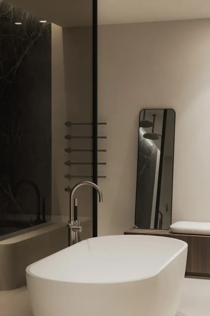Vrijstaand bad met badkraan voor een donkere marmeren wand, Nieuwbouwwoning in Roeselare, interieur Laura Calleeuw