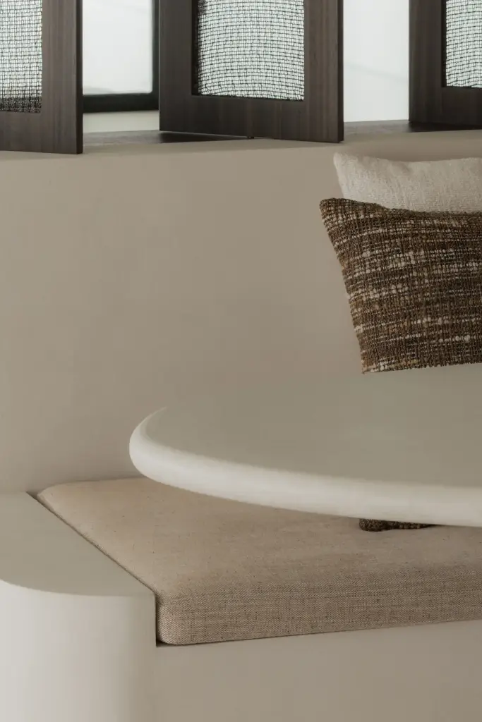 Detail van afgeronde zitbank, tafel en travertijn in de eethoek, Nieuwbouwwoning in Roeselare, interieur Laura Calleeuw