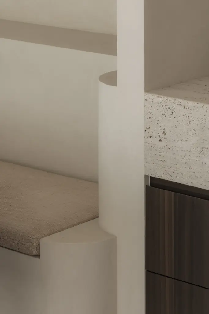 Detail van afgeronde zitbank, tafel en travertijn in de eethoek, Nieuwbouwwoning in Roeselare, interieur Laura Calleeuw