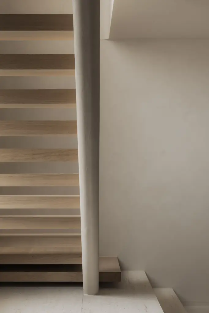 Zwevende eikenhouten trap met travertijn treden en gestucte wand, Nieuwbouwwoning in Roeselare, interieur Laura Calleeuw