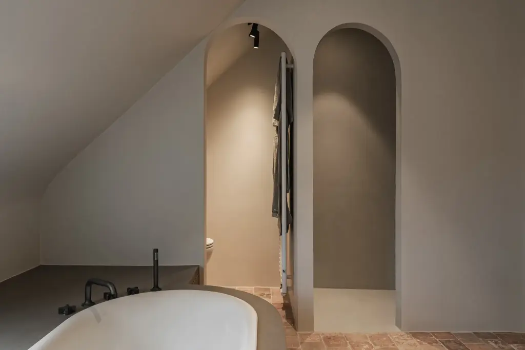 Badkamer met vrijstaand bad en twee boogvormige nissen, Schuur in Westkapelle, interieur Laura Calleeuw