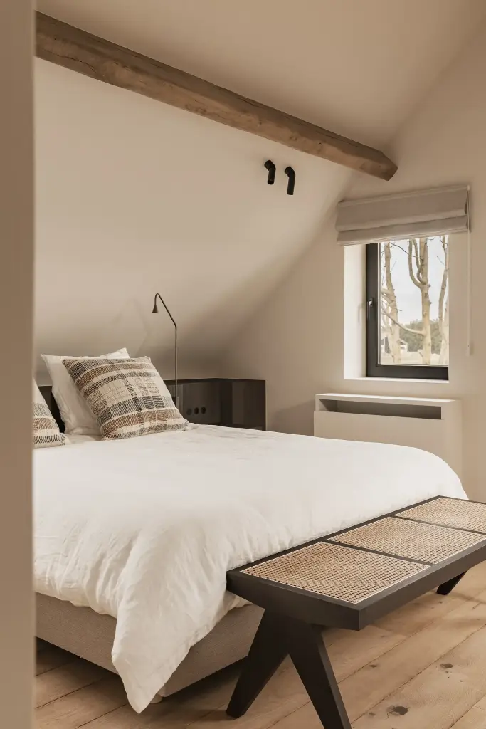Bed met rotan bankje onder een eikenhouten balk, Schuur in Westkapelle, interieur Laura Calleeuw