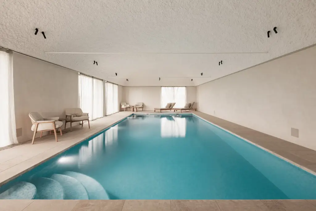 Binnenzwembad met tongewelf, ligstoelen en fauteuils, Schuur in Westkapelle, interieur Laura Calleeuw