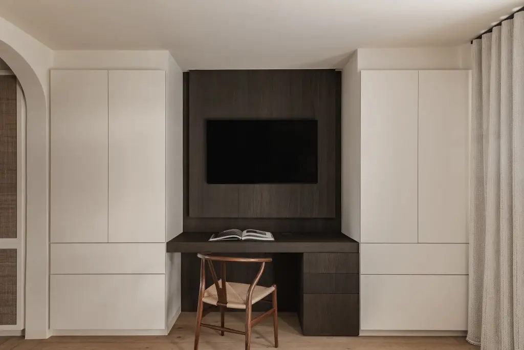 Bureau met televisie in donker eiken tussen witte kasten en gordijn, Schuur in Westkapelle, interieur Laura Calleeuw