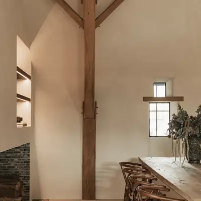 Eetkamer met lange eikenhouten tafel, wishbone stoelen en klein raam, Schuur in Westkapelle, interieur Laura Calleeuw