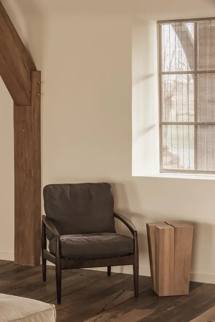 Fauteuil en houten bijzettafel naast het raam, Schuur in Westkapelle, interieur Laura Calleeuw