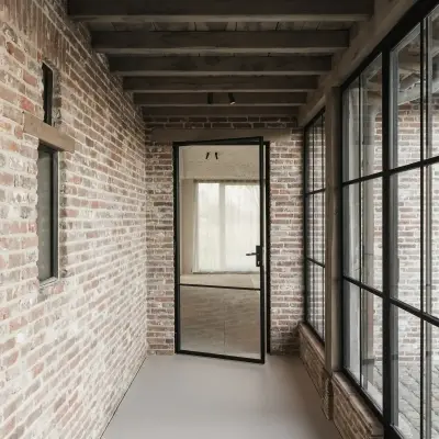 Gang met baksteenwand en stalen glaswand naar het zwembad, Schuur in Westkapelle, interieur Laura Calleeuw