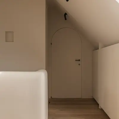 Gang met boogdeur onder het schuine dak en gestucte leuning, Schuur in Westkapelle, interieur Laura Calleeuw