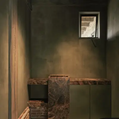 Toilet in groene kalkverf met fonteintje in bruin marmer, Schuur in Westkapelle, interieur Laura Calleeuw