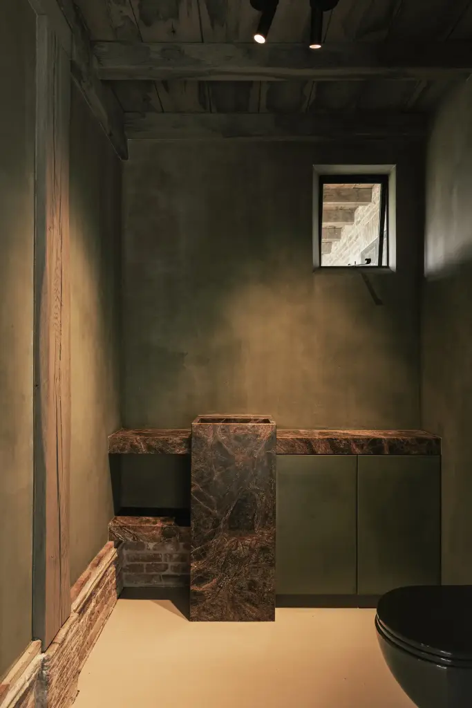 Toilet in groene kalkverf met fonteintje in bruin marmer, Schuur in Westkapelle, interieur Laura Calleeuw