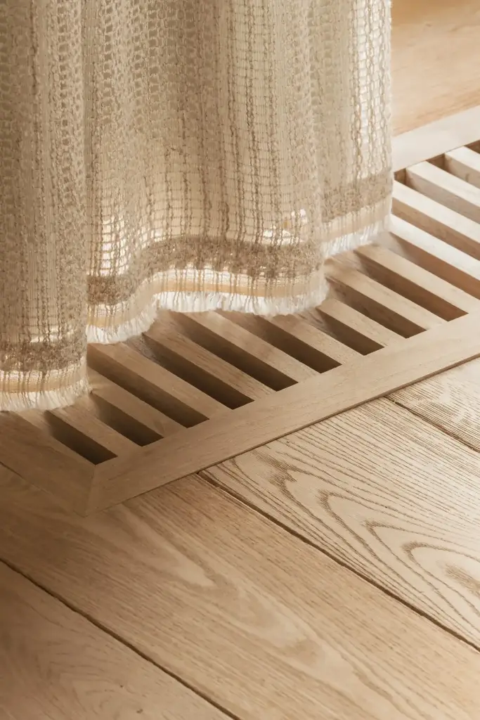 Gordijn boven een ventilatierooster in een eikenhouten vloer, Schuur in Westkapelle, interieur Laura Calleeuw