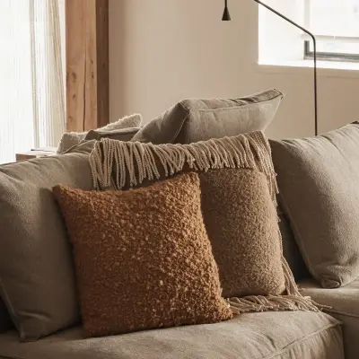 Hoekzetel met sierkussens en zwarte leeslamp, Schuur in Westkapelle, interieur Laura Calleeuw
