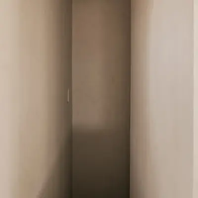 Smalle gang met verlichte nis in microcement, Schuur in Westkapelle, interieur Laura Calleeuw