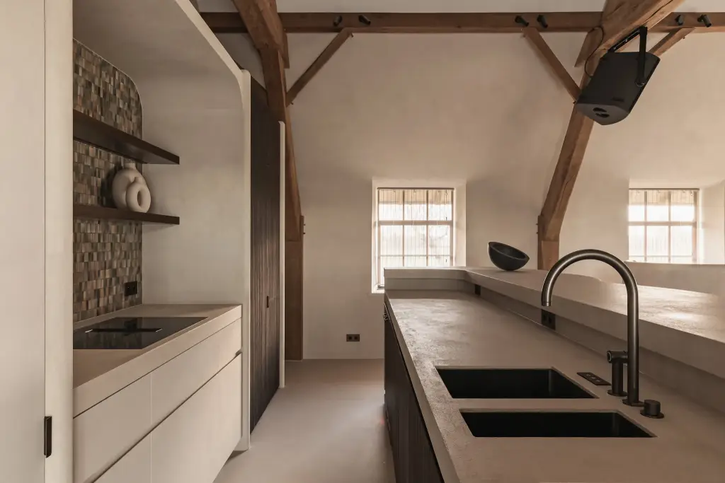 Keukeneiland met dubbele spoelbak en kookplaat onder eikenhouten spanten, Schuur in Westkapelle, interieur Laura Calleeuw