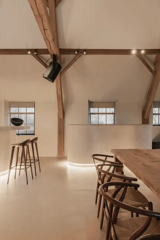 Keuken en eethoek met eikenhouten tafel en wishbone stoelen onder de spanten, where heritage finds a new purpose, interieur Laura Calleeuw