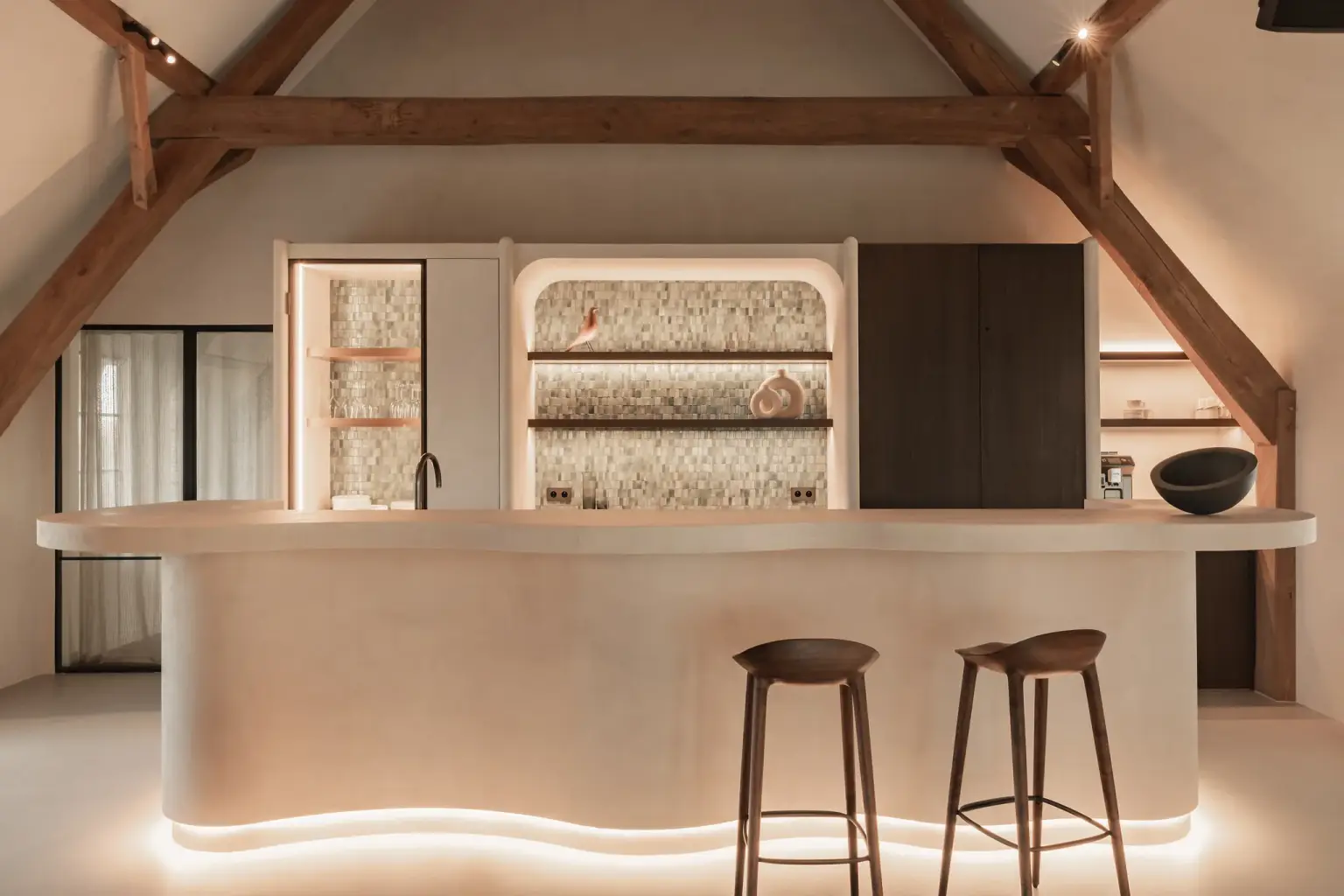 Keukeneiland met barkrukken voor een nis met verlichte planken en tegelrugwand, Schuur in Westkapelle, interieur Laura Calleeuw