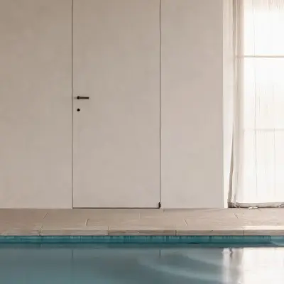 Onzichtbare deur in microcement naast het zwembad, Schuur in Westkapelle, interieur Laura Calleeuw