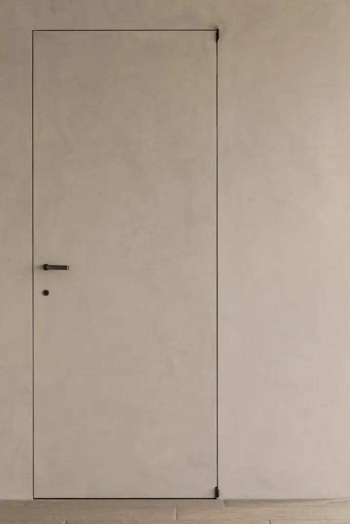 Onzichtbare deur in microcement naast het zwembad, Schuur in Westkapelle, interieur Laura Calleeuw