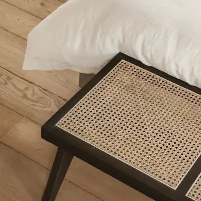 Detail van een rotan bankje op een eikenhouten plankenvloer, Schuur in Westkapelle, interieur Laura Calleeuw