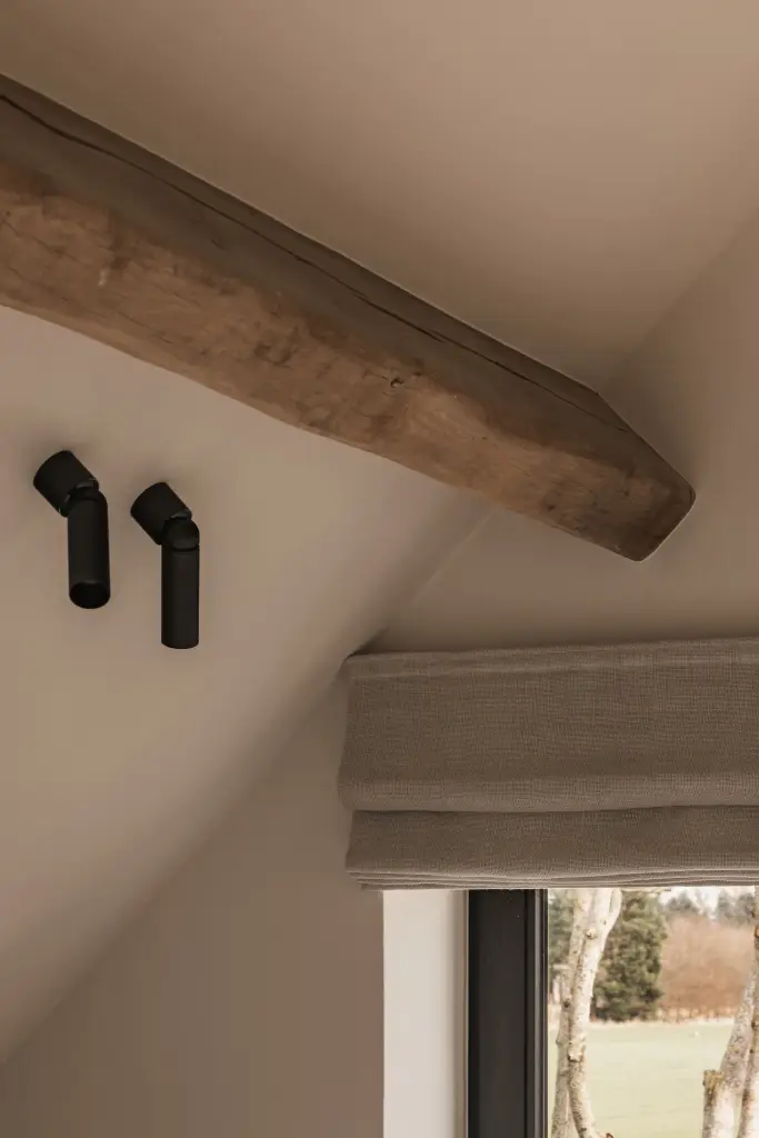 Zwarte spots aan een eikenhouten balk bij het raam, Schuur in Westkapelle, interieur Laura Calleeuw