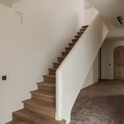 Trap met eikenhouten treden, gestucte leuning en vloer in visgraat gebakken baksteen, Schuur in Westkapelle, interieur Laura Calleeuw