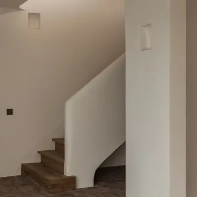 Trap met eikenhouten treden, gestucte leuning en vloer in visgraat gebakken baksteen, Schuur in Westkapelle, interieur Laura Calleeuw