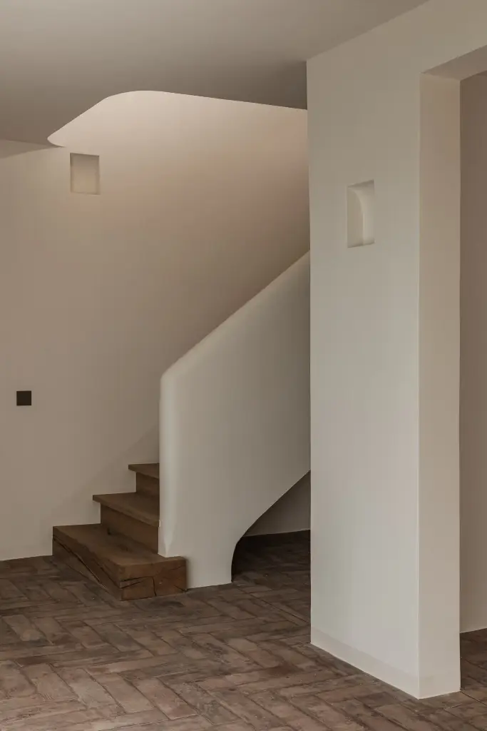 Trap met eikenhouten treden, gestucte leuning en vloer in visgraat gebakken baksteen, Schuur in Westkapelle, interieur Laura Calleeuw