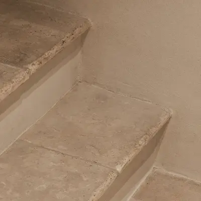 Trap met treden in natuursteen en inbouwkast in microcement, Schuur in Westkapelle, interieur Laura Calleeuw
