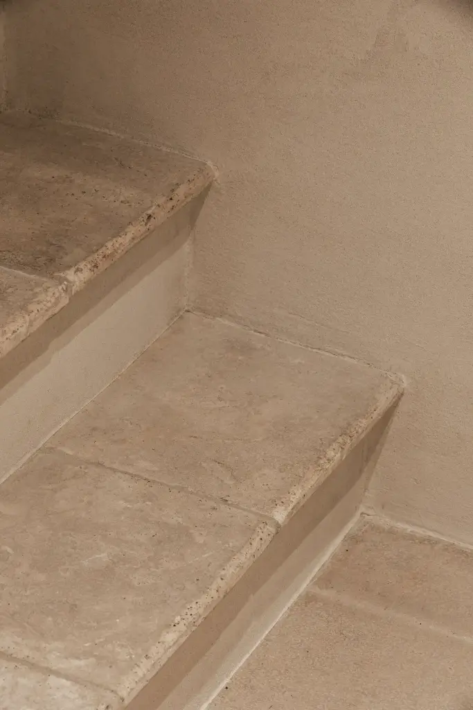 Trap met treden in natuursteen en inbouwkast in microcement, Schuur in Westkapelle, interieur Laura Calleeuw