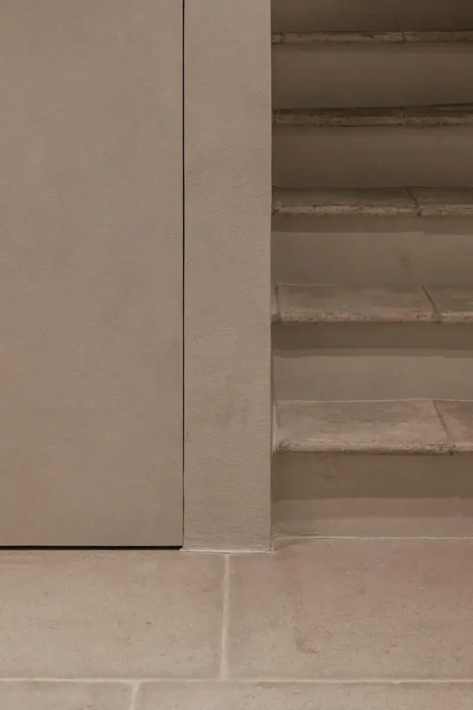 Trap met treden in natuursteen en inbouwkast in microcement, Schuur in Westkapelle, interieur Laura Calleeuw