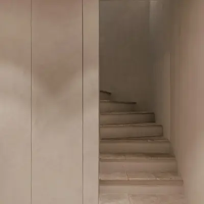Trap met treden in natuursteen en inbouwkast in microcement, Schuur in Westkapelle, interieur Laura Calleeuw
