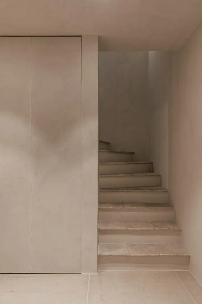 Trap met treden in natuursteen en inbouwkast in microcement, Schuur in Westkapelle, interieur Laura Calleeuw