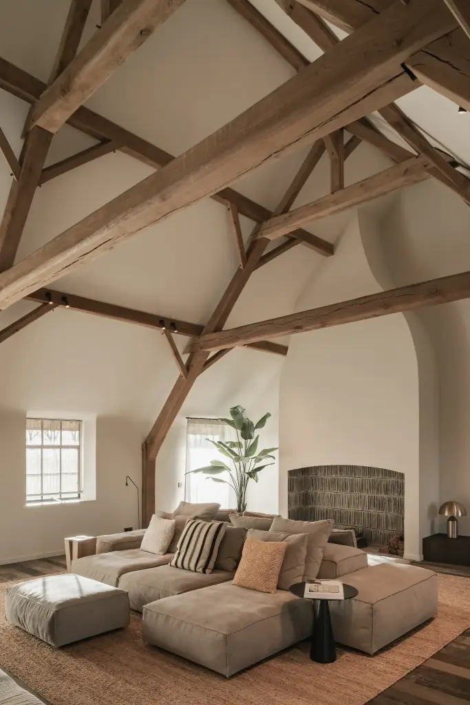 Woonkamer onder het spantendak met modulaire hoekzetel en schouw, Schuur in Westkapelle, interieur Laura Calleeuw