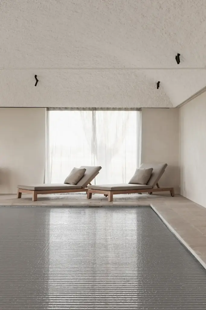 Zwembad met ligstoelen, fauteuils en rolluik over het water, Schuur in Westkapelle, interieur Laura Calleeuw