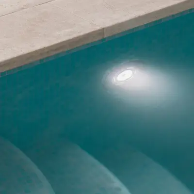 Detail van de zwembadrand in natuursteen met blauwe mozaïektegels, Schuur in Westkapelle, interieur Laura Calleeuw