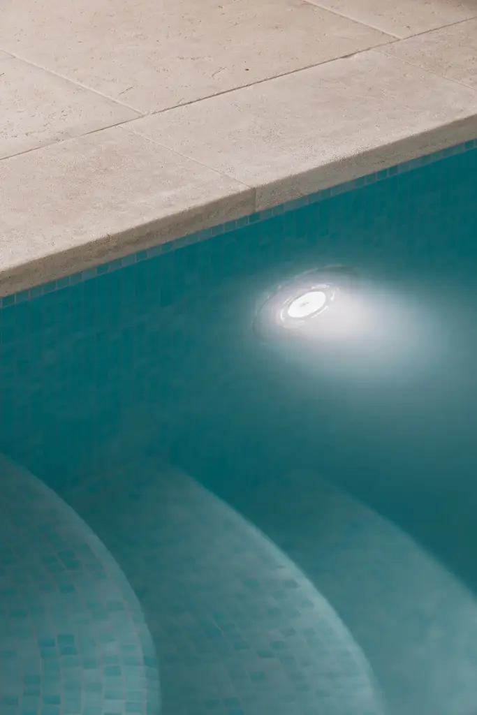 Detail van de zwembadrand in natuursteen met blauwe mozaïektegels, Schuur in Westkapelle, interieur Laura Calleeuw