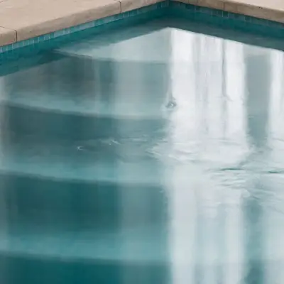 Detail van de zwembadrand in natuursteen met blauwe mozaïektegels, Schuur in Westkapelle, interieur Laura Calleeuw