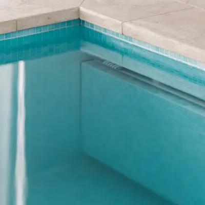 Detail van de zwembadrand in natuursteen met blauwe mozaïektegels, Schuur in Westkapelle, interieur Laura Calleeuw