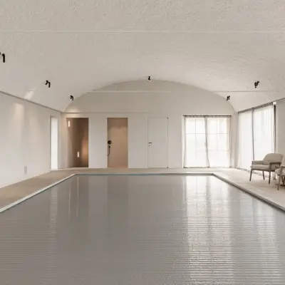 Zwembad onder tongewelf met microcement deuren aan het einde, Schuur in Westkapelle, interieur Laura Calleeuw