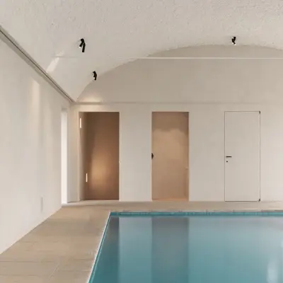 Zwembad onder tongewelf met microcement deuren aan het einde, Schuur in Westkapelle, interieur Laura Calleeuw